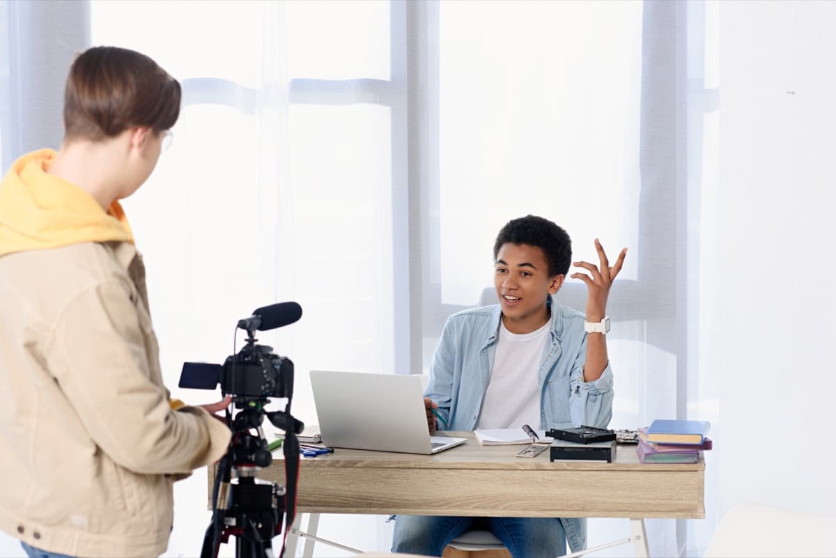 Leerling filmt een presentator met een camera